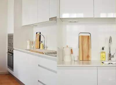 a white kitchen with white cabinets and appliances at Elisa Apartment in Porto