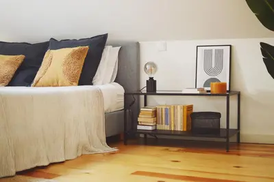 a bedroom with a bed with a side table with books at Elisa Apartment in Porto