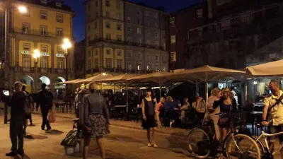 a group of people walking around a city at night at Historic Oporto Apartment at oporto UNESCO area, in front of Porto Wine caves in Porto