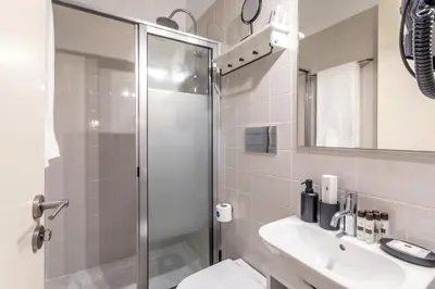 a bathroom with a shower and a toilet and a sink at Apartamentos Villa Bolhao in Porto