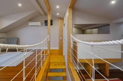 a room with a suspended bed and a staircase at YOUROPO - ExtendALL in Porto