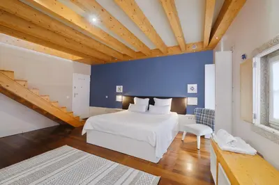 a bedroom with a white bed and a blue wall at YOUROPO - ExtendALL in Porto