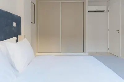 a bedroom with a white bed and a large window at Marquês Deluxe Apartment in Porto