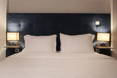a large bed with two white pillows and two lamps at Marquês Deluxe Apartment in Porto