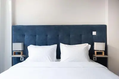 a large bed with a blue headboard and two lamps at Marquês Deluxe Apartment in Porto