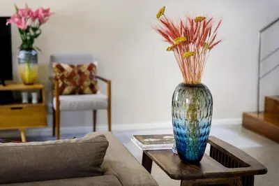 a vase with flowers on a table in a living room at Casas Da Formiga - Riverview Terrace and Pool in Porto