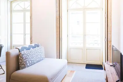 a living room with a couch and a door at APOSENTUS - Charming Center Apartment with Balcony in Porto