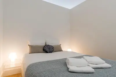 a bedroom with a bed with two towels on it at Casa da Luz - Lighthouse of Porto in Porto
