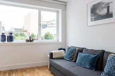 a living room with a gray couch and a window at Casa da Luz - Lighthouse of Porto in Porto