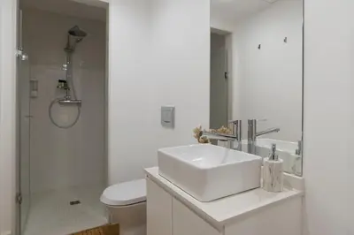 a white bathroom with a sink and a shower at Casa da Luz - Lighthouse of Porto in Porto