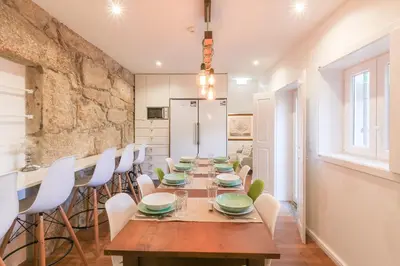 a dining room with a long table and white chairs at PORTO CONCEPT HOME - Paranhos in Porto