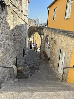 two people walking down an alley between two buildings at By this River in Porto
