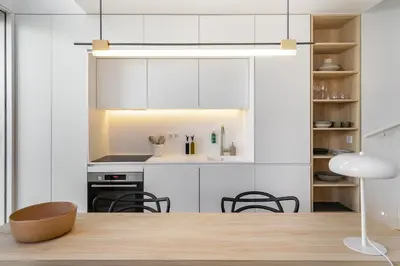 a kitchen with white cabinets and a table and chairs at Canto De Luz - Luxury Maison in Porto