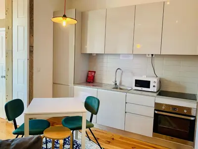 a kitchen with a table and chairs and a microwave at Oporto Chic&Cozy - Santo Ildefonso in Porto