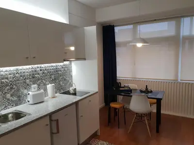 a kitchen with a sink and a table with chairs at Porto Central City Heart I & II in Porto