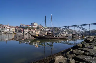 a boat is docked in a harbor with a bridge at Port Wine Flats in Vila Nova de Gaia
