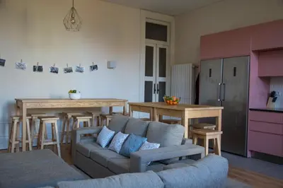 a living room with a couch and a kitchen at Sweet Swell in Porto