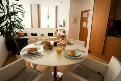 a white table with plates of food on it at Downtown Porto Relaxed Apartment with Private Yard in Porto