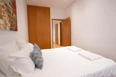 a bedroom with a white bed with two pillows at Downtown Porto Relaxed Apartment with Private Yard in Porto