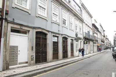 two people walking down a street next to a building at Cedofeita Exclusive with parking included in Porto