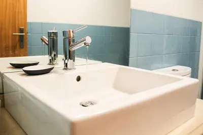 a white sink in a bathroom with a toilet at Cedofeita Exclusive with parking included in Porto