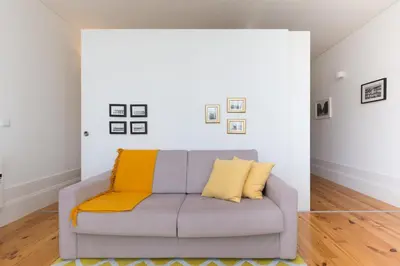 a living room with a couch with yellow pillows at Host Wise - Colorful Stunning Sunlit Flat in Porto