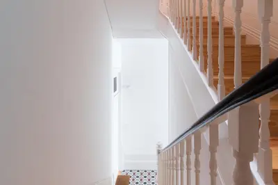 a staircase in a home with white walls and wood floors at Host Wise - Colorful Stunning Sunlit Flat in Porto