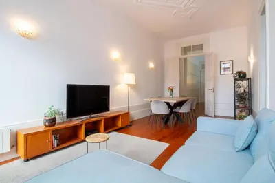 a living room with a blue couch and a tv at LovelyStay - Aurora Heights Apartment in Porto