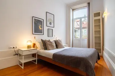 a white bedroom with a bed and a window at LovelyStay - Aurora Heights Apartment in Porto