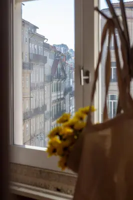 a window with a bunch of yellow flowers in a bag at LovelyStay - Aurora Mezzanine in Porto