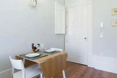 a kitchen with a wooden table with two white chairs at Host Wise - Charming Flat with Netflix - River View in Porto