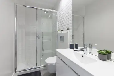 a white bathroom with a shower and a toilet at Host Wise - Charming Flat with Netflix - River View in Porto