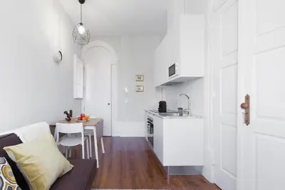 a kitchen and living room with a couch and a table at Host Wise - Charming Flat with Netflix - River View in Porto