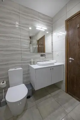a bathroom with a toilet and a sink and a mirror at FLH Porto Spacious Apartment with Balcony in Porto