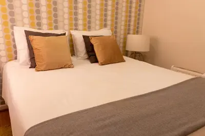 a large bed with white sheets and pillows at North Star Flats @ Dom Luís I Bridge in Vila Nova de Gaia