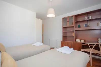 a bedroom with two beds and a desk and a table at Liiiving in Porto | Bright Light Apartment in Porto