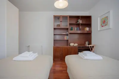 two white beds in a room with a book shelf at Liiiving in Porto | Bright Light Apartment in Porto