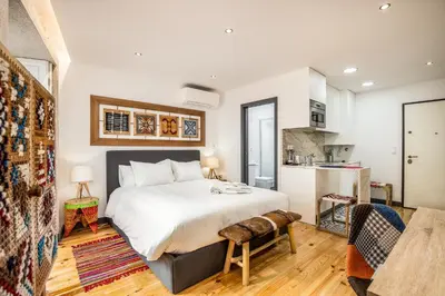 a bedroom with a large bed and a kitchen at Tito Studio Terrace in Porto