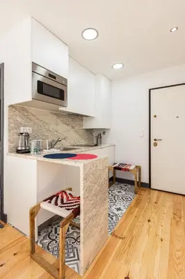 a kitchen with white cabinets and a counter top at Tito Studio Terrace in Porto