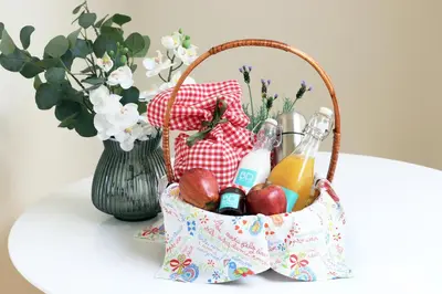a basket of fruit and drinks on a table with a vase at HM - Ribeira São João 2E in Porto