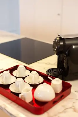 a tray filled with cups and saucers on a counter at Almada Luxurious Duplex by DA'HOME in Porto