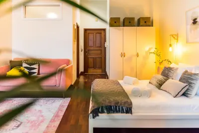 a bedroom with a bed and a couch at DA'HOME - Cedofeita Art Studio in Porto