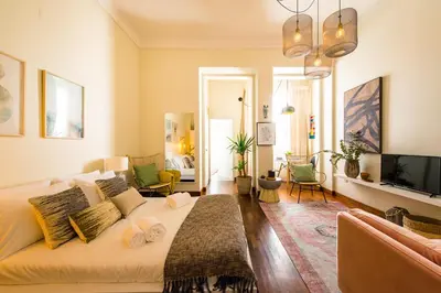 a bedroom with a bed and a living room at DA'HOME - Cedofeita Art Studio in Porto