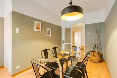 a dining room with a glass table and black chairs at DA'HOME - Marquês Lovely 2BD Apartment in Porto
