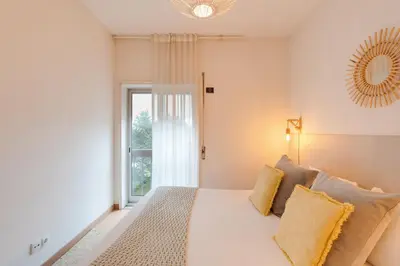 a bedroom with a white bed with a window at DA'HOME - Marquês Lovely 2BD Apartment in Porto