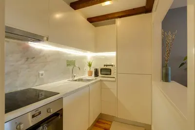 a white kitchen with a sink and a microwave at DA'HOME - Vitoria Duplex Apartment in Porto