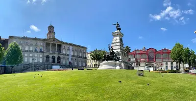 a large building with a statue in the middle of a field at Comercio RIBEIRA Luxury Penthouse Apartment in Porto
