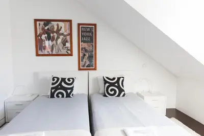 a bedroom with two beds and two pictures on the wall at APOSENTUS - Downtown Porto Modern Penthouse in Porto