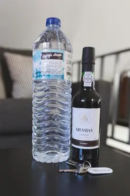 a bottle of water next to a bottle of wine at APOSENTUS - Downtown Porto Modern Penthouse in Porto