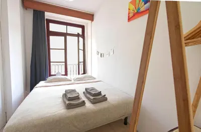 a bedroom with a bed with two towels on it at Ribeira Vintage Suite in Porto